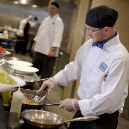 chef stirring pan of food