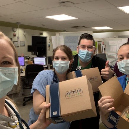 group of workers gather to prepare food packages during the covid-19 pandemic