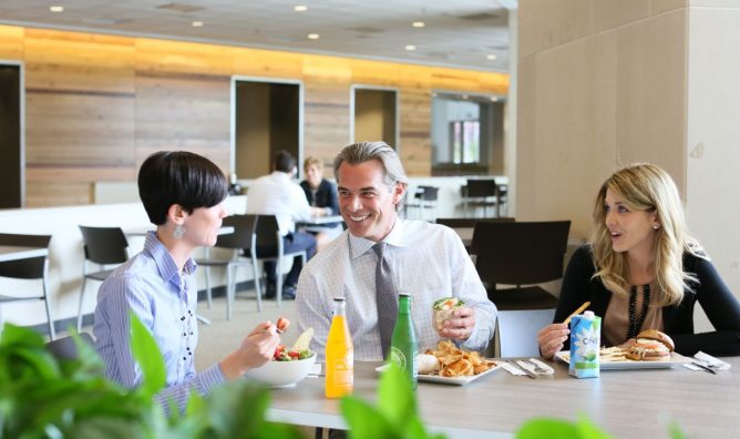 three workers in business attire gather for a lunch break