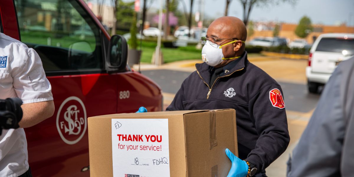 First responder holds box of food