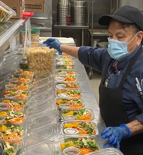 Woman preps Zurich Community lunches in proper safety gear