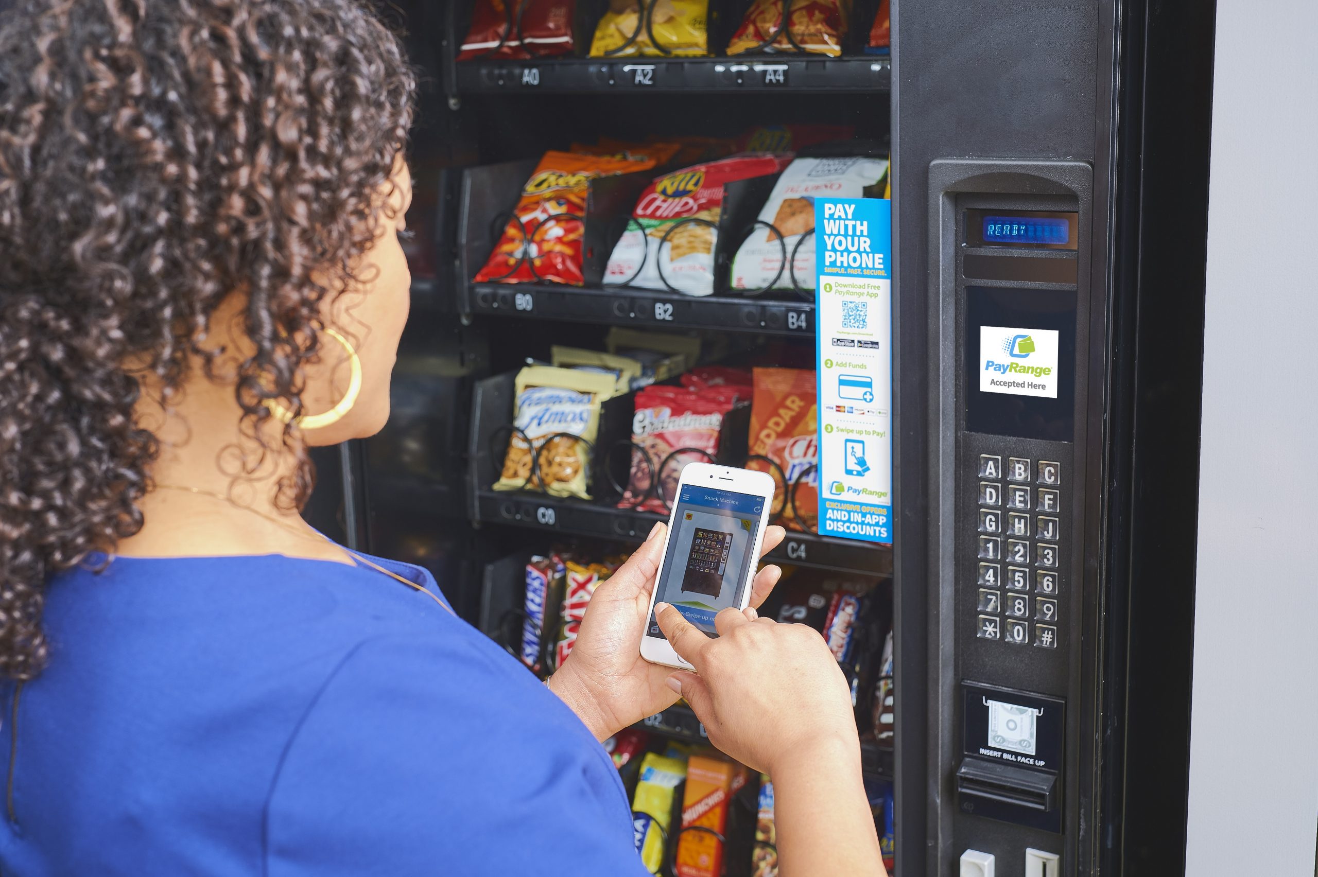 Woman uses Payrange to pay at vending machine with her phone