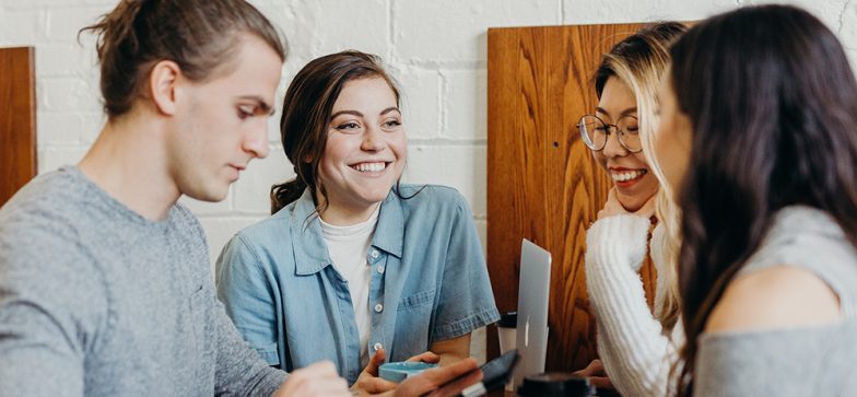 Four students meet at table to do work and enjoy coffee