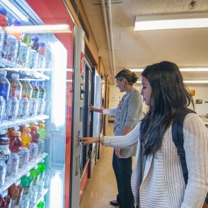 two women make their selections at the vending machine