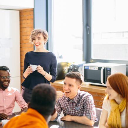 employees laughing and smiling over coffee