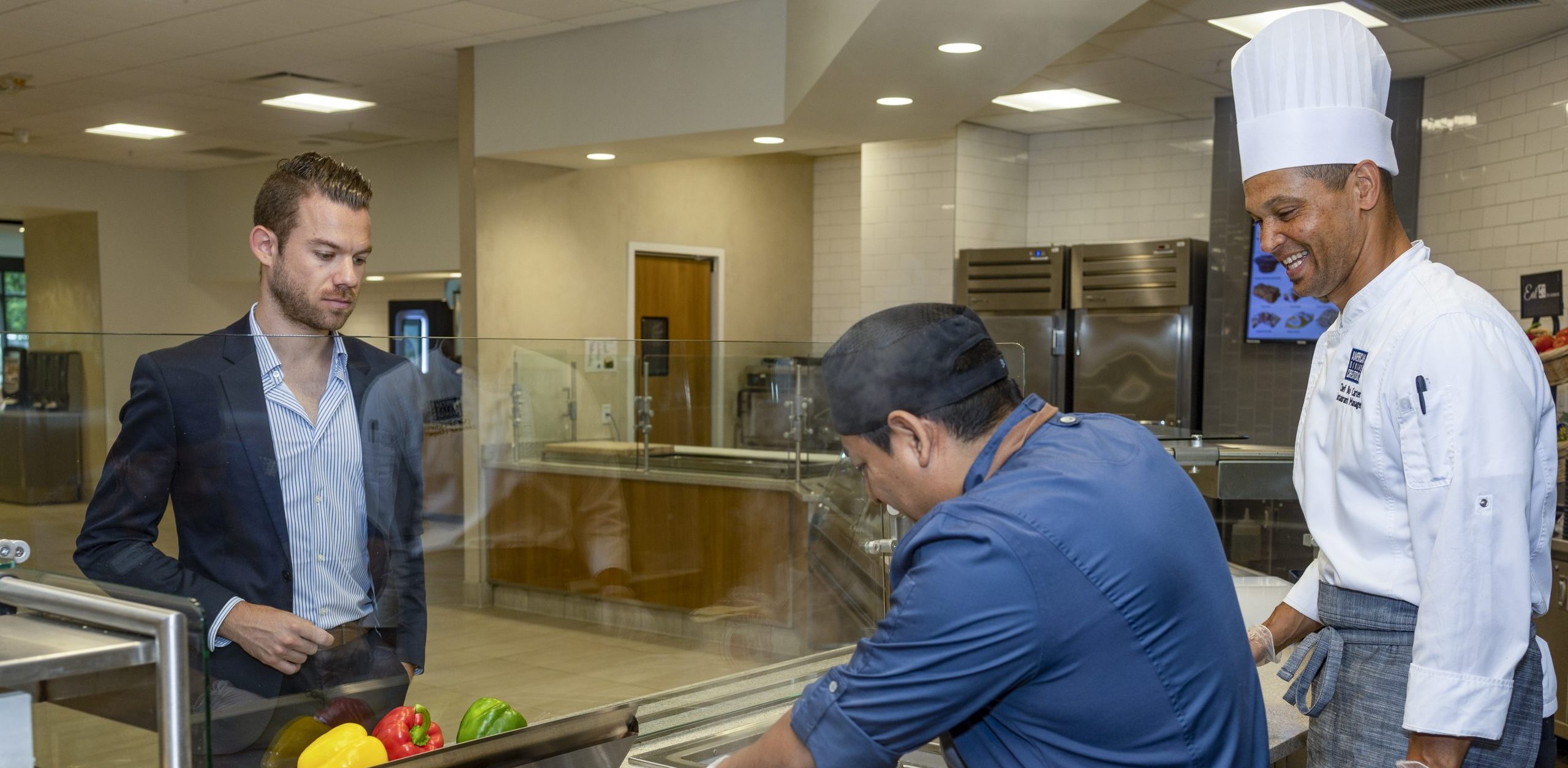 chefs preparing food in front of guest